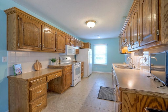 kitchen with white appliances, tasteful backsplash, brown cabinets, light countertops, and a sink