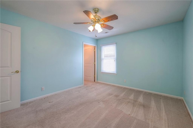 unfurnished room featuring light colored carpet, visible vents, ceiling fan, and baseboards