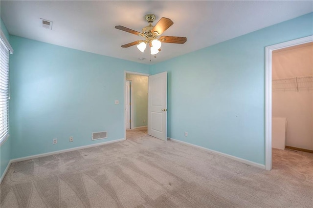 unfurnished bedroom with a spacious closet, a closet, visible vents, and baseboards