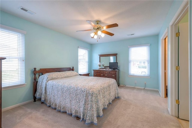 bedroom featuring visible vents, light carpet, and multiple windows