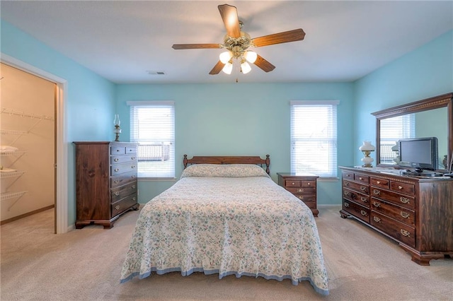 bedroom with multiple windows, visible vents, and light colored carpet