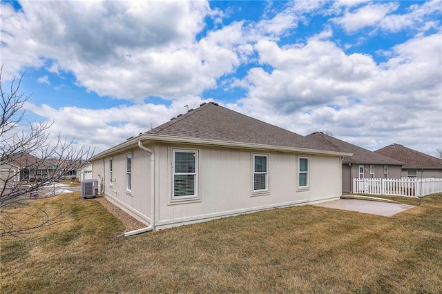 back of property featuring fence, central AC unit, a patio, and a yard