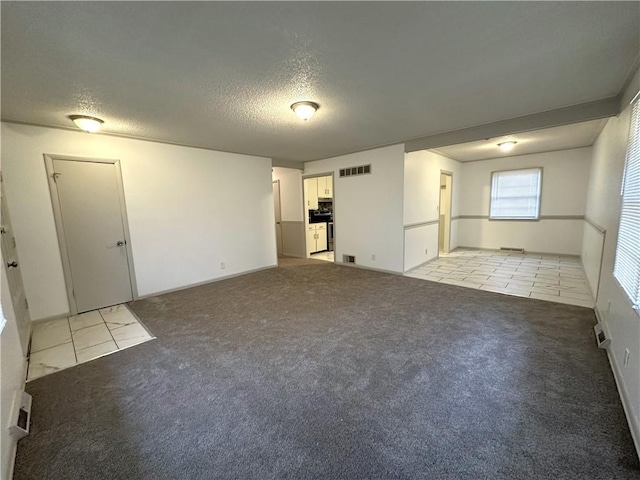 carpeted spare room with a textured ceiling