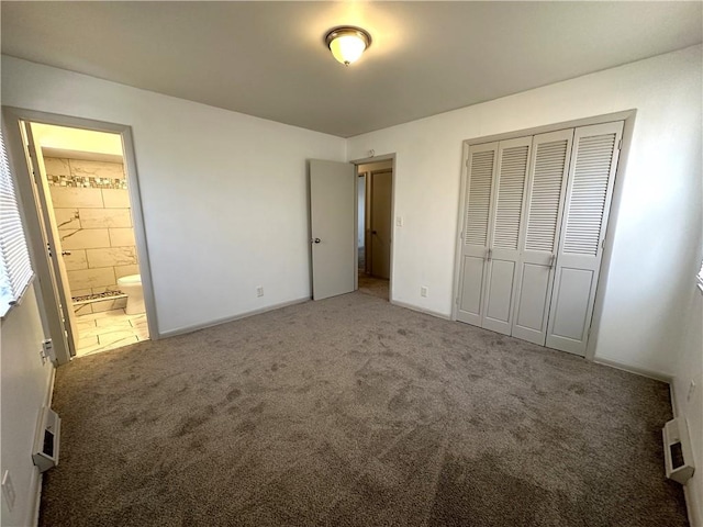 unfurnished bedroom with ensuite bathroom, carpet flooring, and a closet