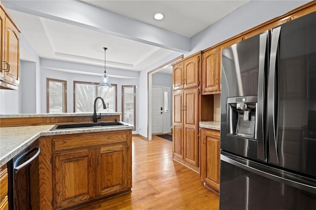 kitchen with sink, decorative light fixtures, black dishwasher, refrigerator with ice dispenser, and a raised ceiling