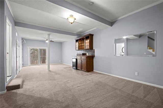 unfurnished living room featuring crown molding, ceiling fan, and carpet flooring