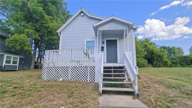 view of front facade with a front yard and central air condition unit