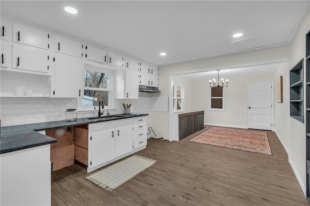 kitchen with backsplash, dark hardwood / wood-style floors, sink, and white cabinets