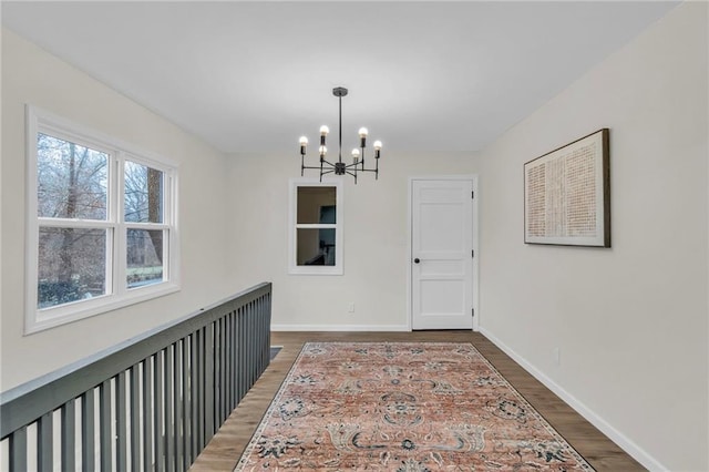 hall featuring dark hardwood / wood-style floors and a notable chandelier