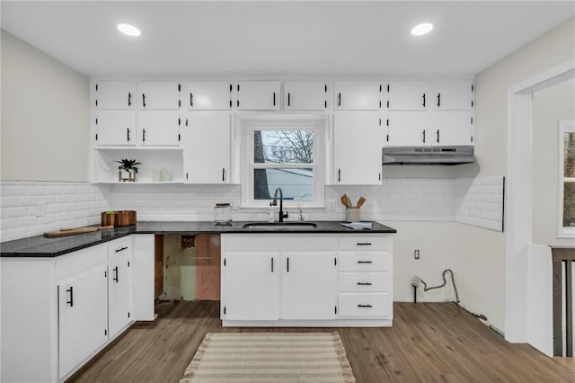 kitchen with sink, backsplash, dark wood-type flooring, and white cabinets