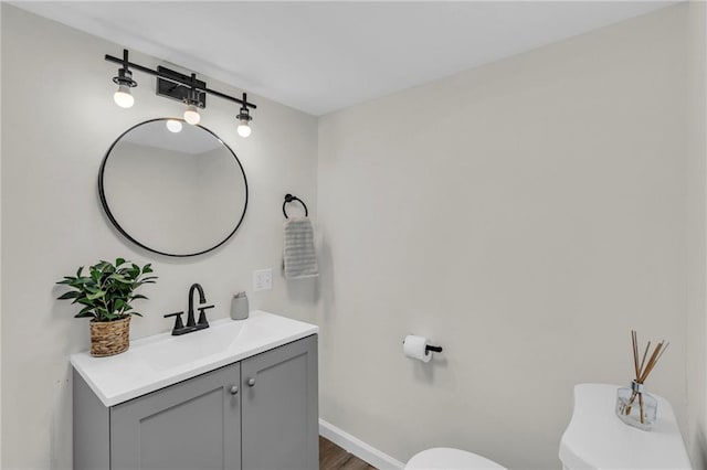 bathroom featuring vanity, toilet, and hardwood / wood-style floors