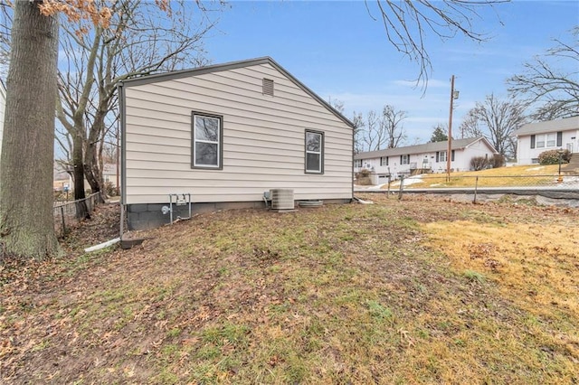 view of property exterior with cooling unit and a lawn