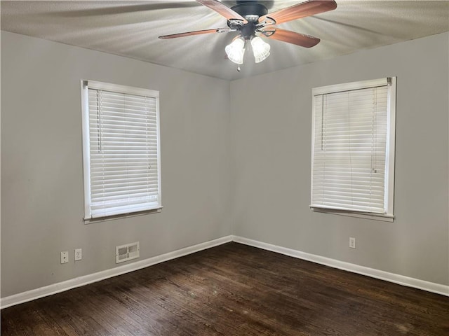 spare room featuring dark wood-type flooring and ceiling fan