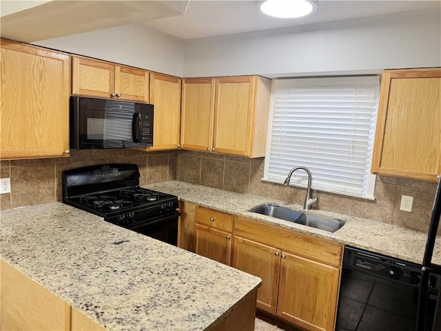 kitchen with light brown cabinetry, tasteful backsplash, sink, light stone counters, and black appliances