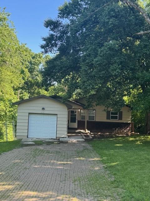 8618 E 32nd St, Kansas City, MO 64129 - ranch-style house with a front lawn, a garage, and driveway