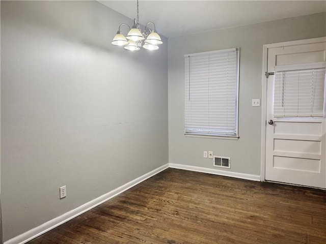 8618 E 32nd St, Kansas City, MO 64129 - unfurnished dining area with a chandelier, dark wood-style floors, and baseboards