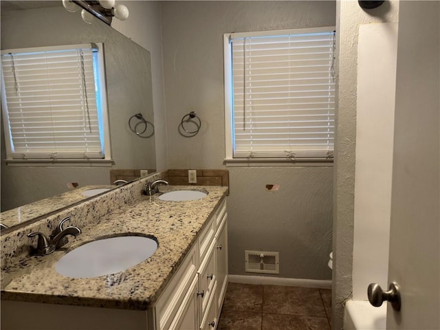 8618 E 32nd St, Kansas City, MO 64129 - bathroom featuring double vanity, baseboards, and tile patterned flooring
