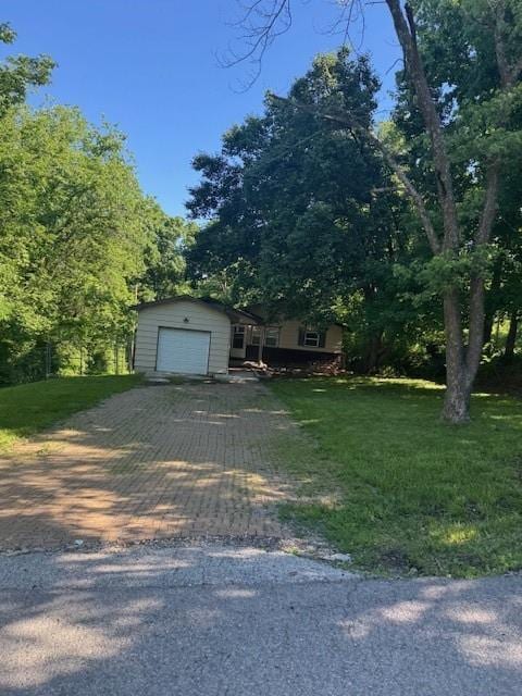 8618 E 32nd St, Kansas City, MO 64129 - view of front facade featuring decorative driveway, a garage, and a front lawn