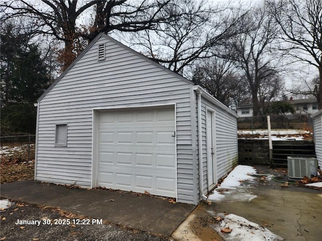 snow covered garage with cooling unit