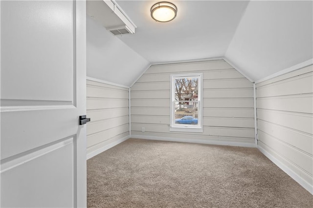 additional living space featuring lofted ceiling and carpet