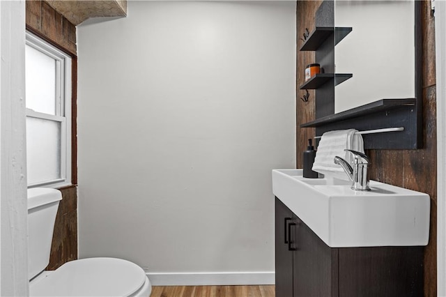 bathroom featuring vanity, wood-type flooring, and toilet