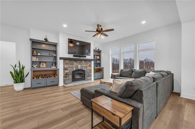 living room featuring a fireplace, recessed lighting, light wood-style floors, ceiling fan, and baseboards