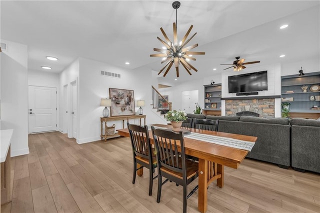 dining room with visible vents, stairs, a stone fireplace, light wood-type flooring, and recessed lighting