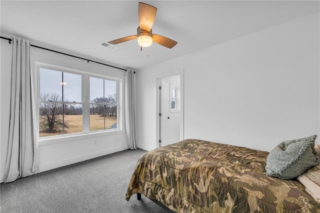 carpeted bedroom with a ceiling fan, visible vents, and baseboards