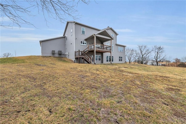 rear view of property featuring a yard, stairway, and a wooden deck