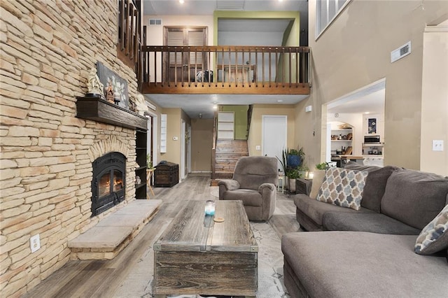 living room featuring a stone fireplace and hardwood / wood-style floors