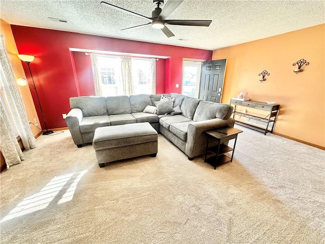 living room featuring ceiling fan, carpet, and a textured ceiling