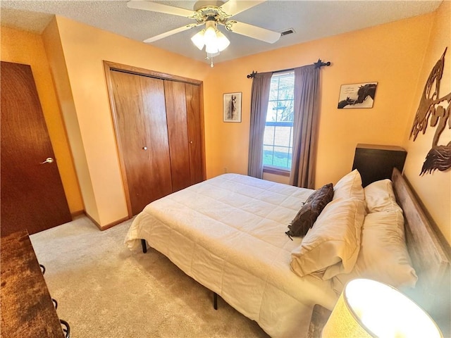 carpeted bedroom featuring a textured ceiling, a closet, and ceiling fan