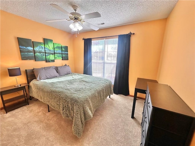 bedroom featuring ceiling fan, carpet flooring, and a textured ceiling