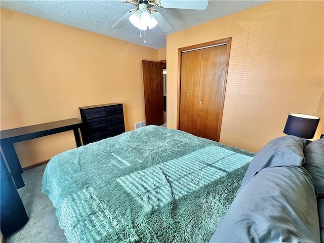 bedroom with ceiling fan, carpet floors, a textured ceiling, and a closet