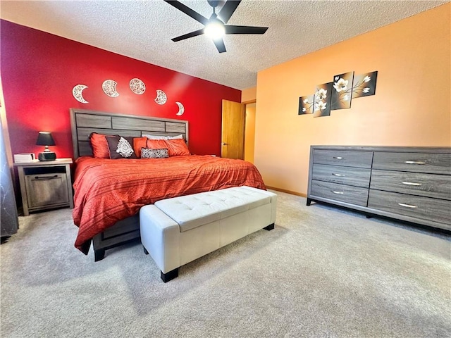 carpeted bedroom featuring ceiling fan and a textured ceiling