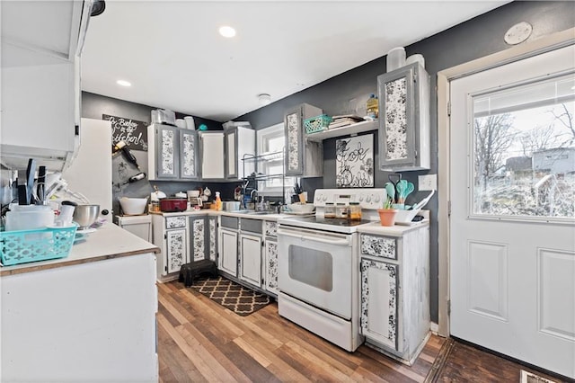 kitchen featuring electric stove, white cabinetry, a healthy amount of sunlight, and hardwood / wood-style floors