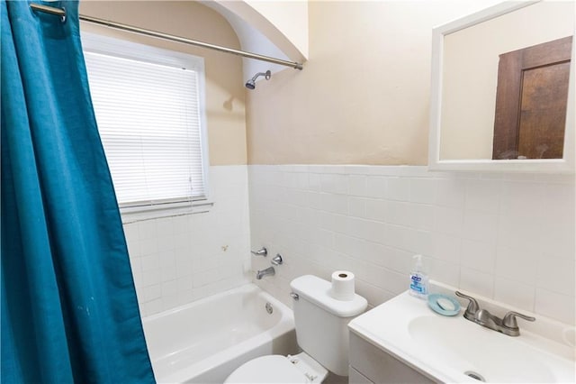 full bath featuring shower / tub combo, a sink, tile walls, and toilet