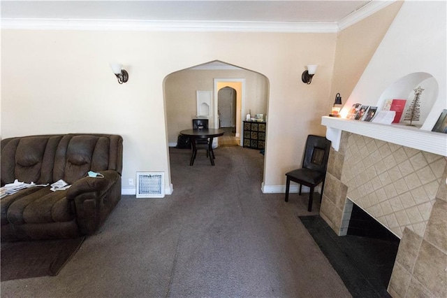 carpeted living room with baseboards, visible vents, arched walkways, and crown molding