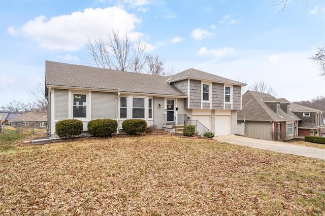 tri-level home with a garage and a front yard