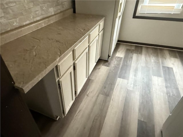 kitchen with white cabinetry, white refrigerator, and light wood-type flooring