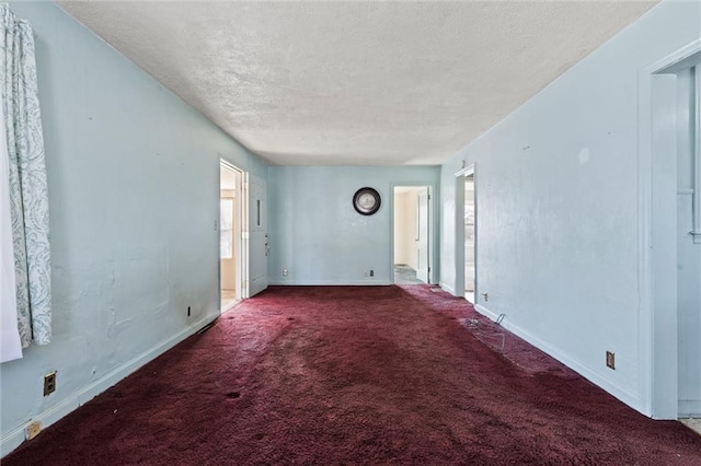 carpeted empty room featuring a textured ceiling