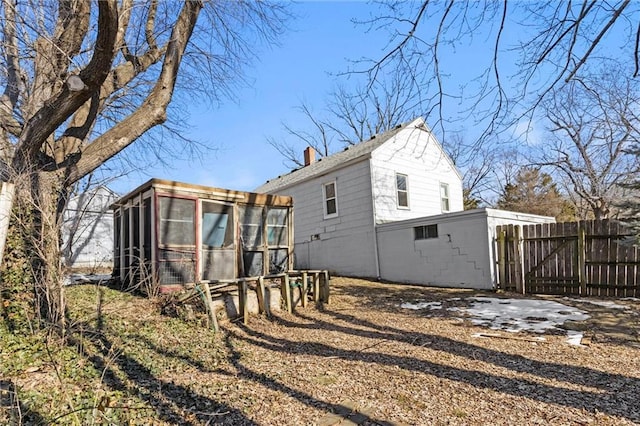 rear view of house featuring a sunroom