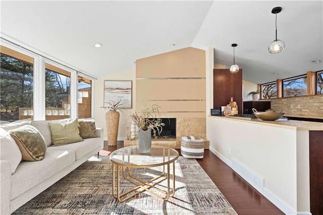 living room with lofted ceiling, a high end fireplace, and dark hardwood / wood-style floors