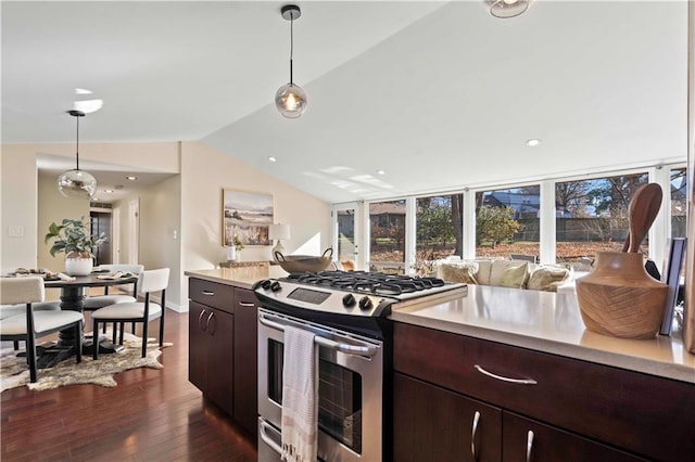 kitchen featuring lofted ceiling, dark wood-type flooring, hanging light fixtures, dark brown cabinetry, and gas stove