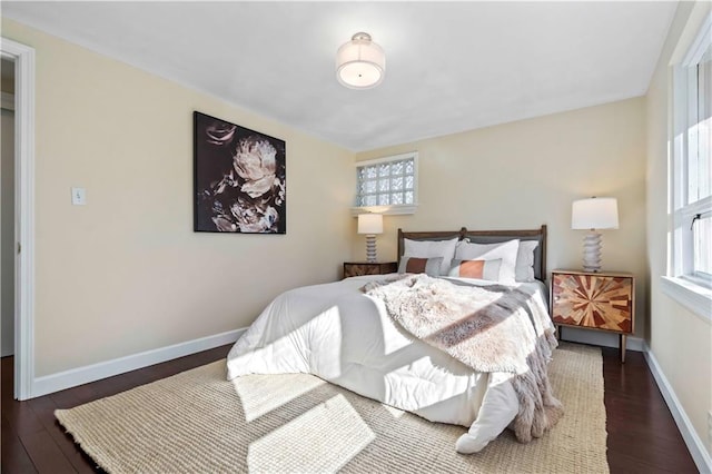 bedroom with dark hardwood / wood-style floors and multiple windows