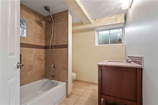 full bathroom featuring vanity, tiled shower / bath combo, tile patterned floors, and toilet