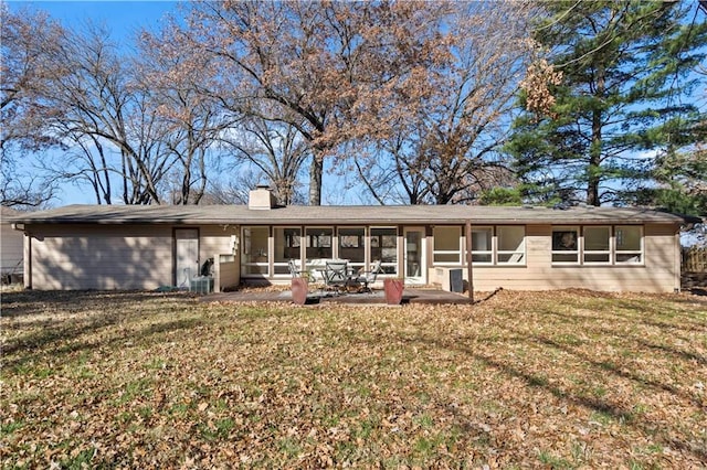 rear view of property featuring a sunroom, a yard, and a patio area