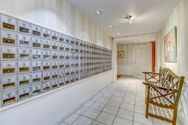 hallway with a mail area and light tile patterned flooring