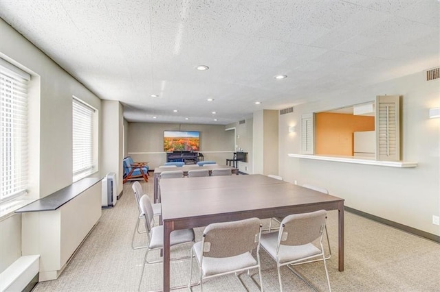 carpeted dining room with radiator