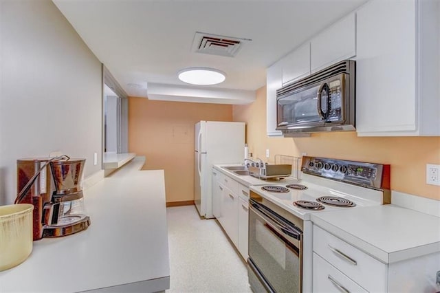 kitchen featuring white cabinets, white fridge, and electric range